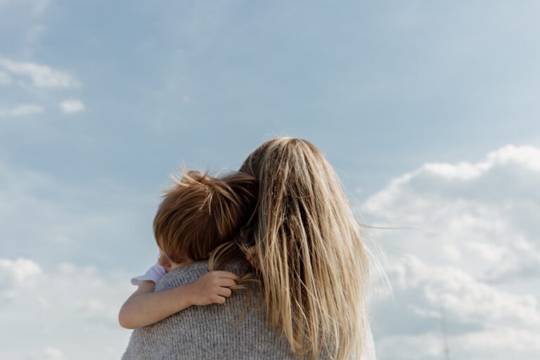 An adult and child sitting together at home, having a thoughtful conversation with gentle expressions.